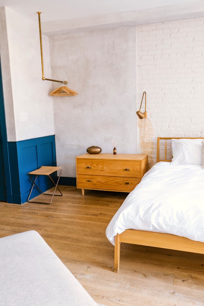 A cozy modern bedroom featuring minimalist design and wooden furniture.